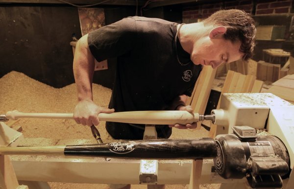 man crafting baseball bat